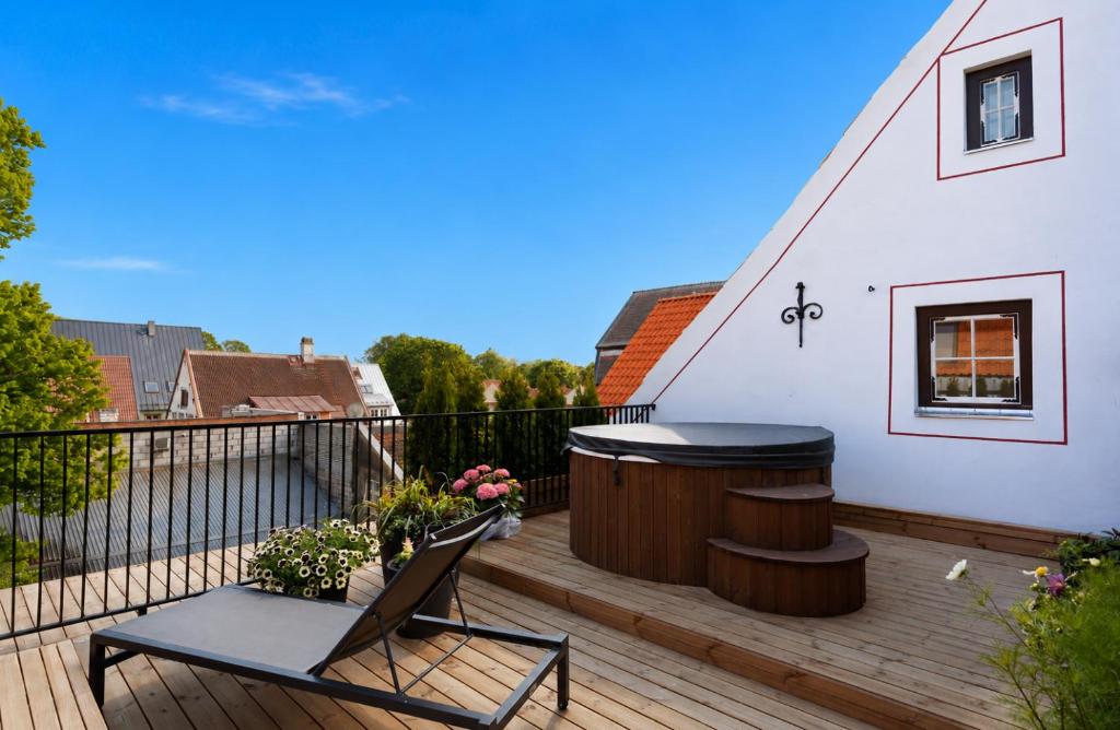 a deck with a hot tub and a chair on it at Jannseni Premium Penthouse I Sauna I Free Parking in Pärnu