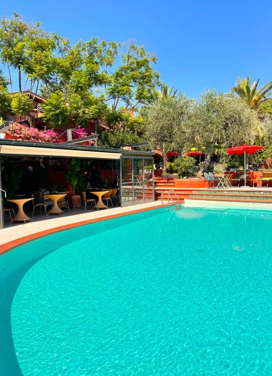 a large blue swimming pool next to a restaurant at Relais San Damian in Imperia
