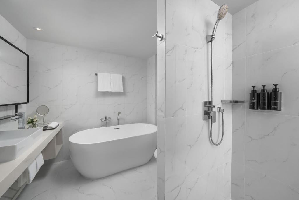 A marble-look bathroom with a freestanding tub and separate rain shower.