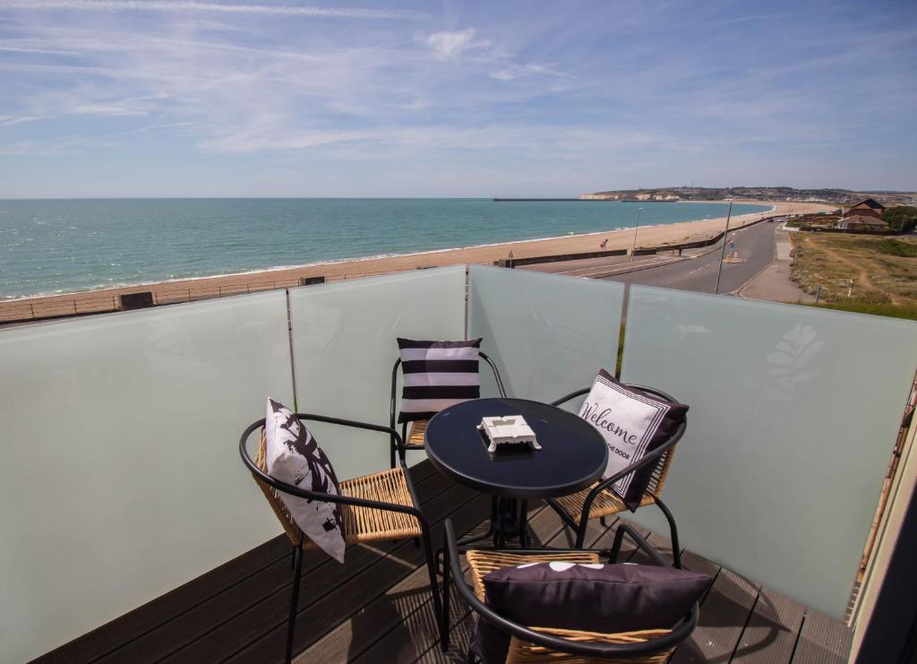 a balcony with a table and chairs and the ocean at Marine View Apartment by Air Premier in Seaford