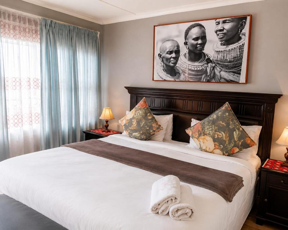 a bedroom with a large bed with a picture on the wall at Radies Bed and Breakfast in Cofimvaba