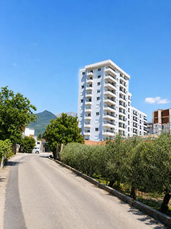 an empty street with a tall white apartment building at Apartpan Lekic in Bar