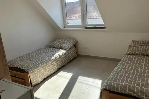 a bedroom with two beds and a window at Meštiansky dom in Stupava