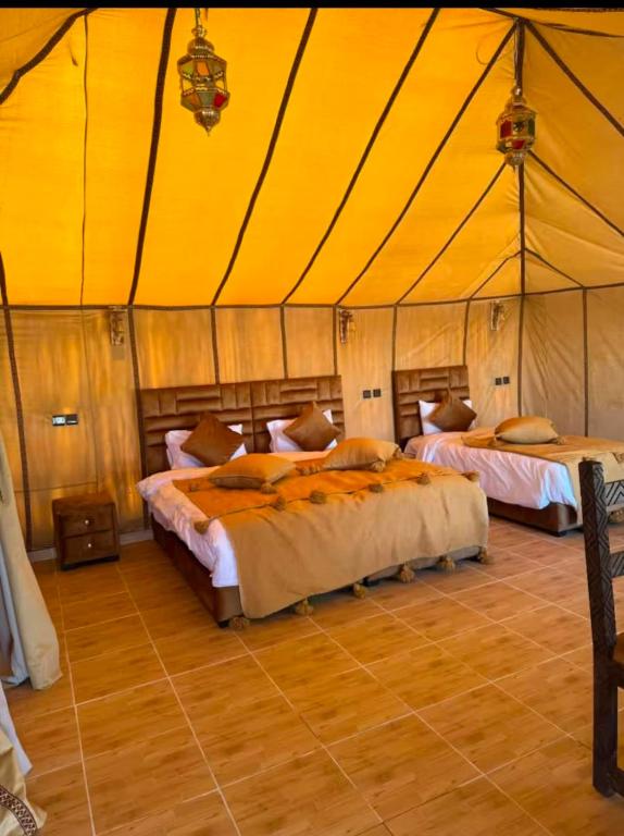 a bedroom with two beds in a tent at Camp Luxury in Merzouga in Merzouga