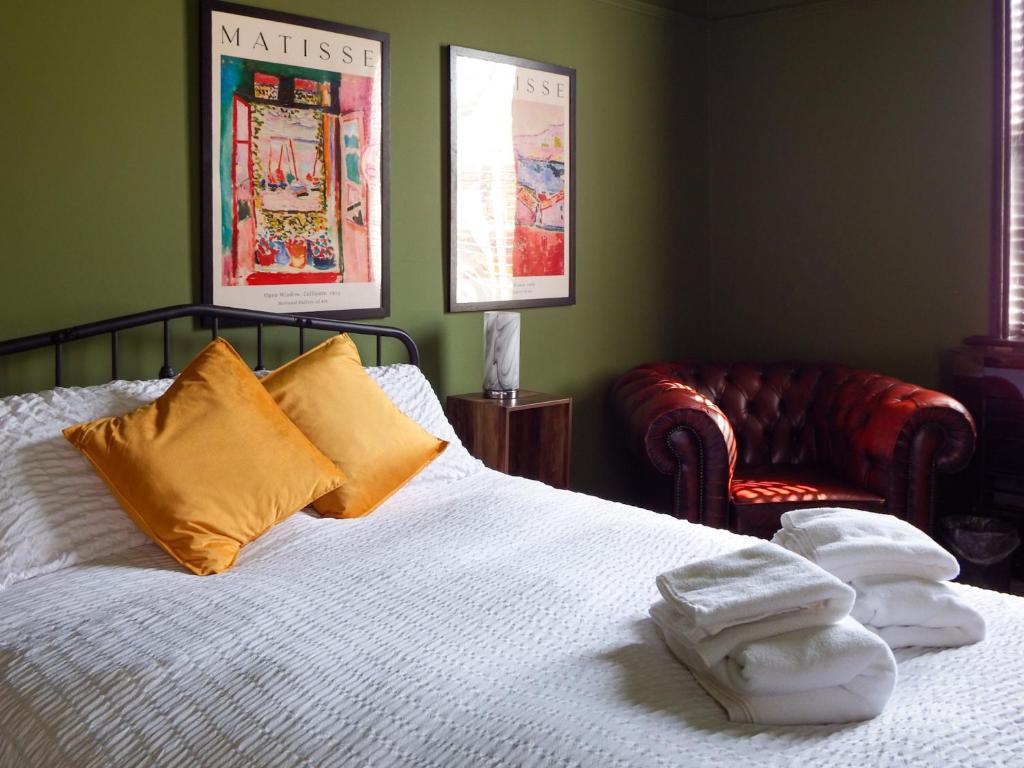 a bedroom with a bed and a chair with towels on it at Cheshire Yeoman - Station Hotel in Hooton Station