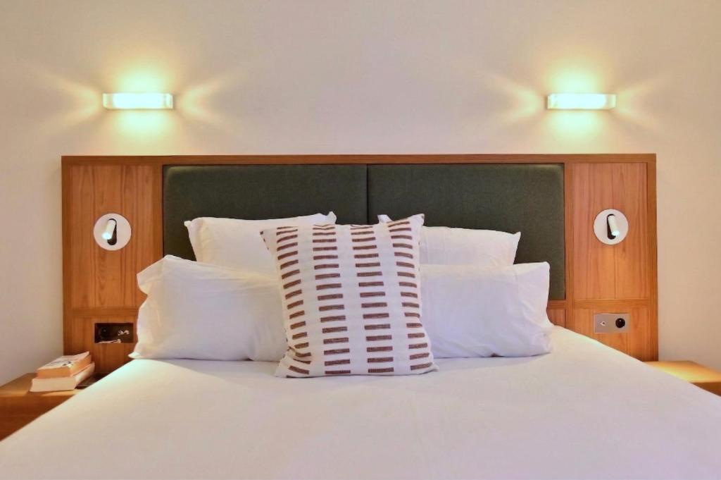 a bedroom with a white bed with white pillows at Hôtel La Pérouse in Nantes