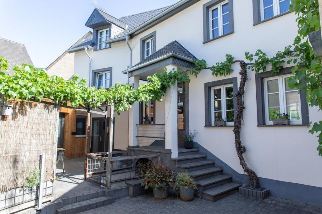 a white house with trees in front of it at Mosel-Cottage in Briedern