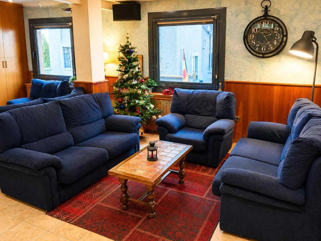 a living room with blue couches and a christmas tree at Hotel Casado in Pas de la Casa