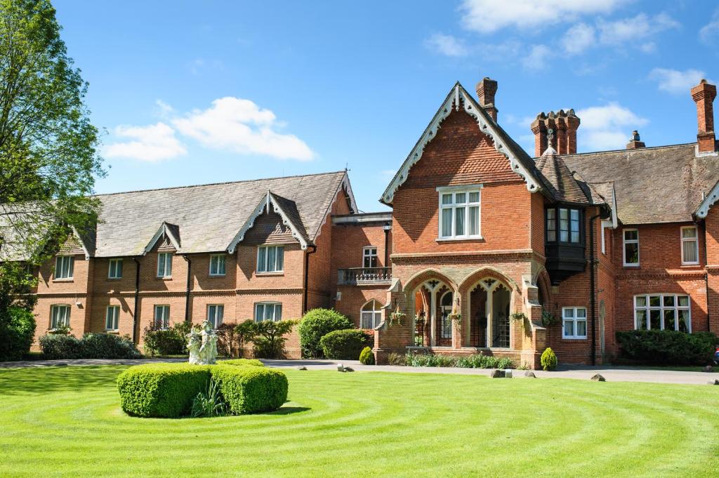 a large brick house with a large lawn at Audleys Wood Hotel, Basingstoke in Basingstoke