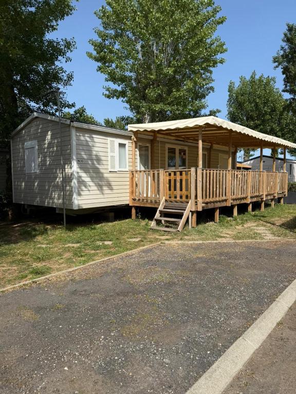 a mobile home with a porch and a deck at La Carabasse-Vias "Te Mahana" in Vias