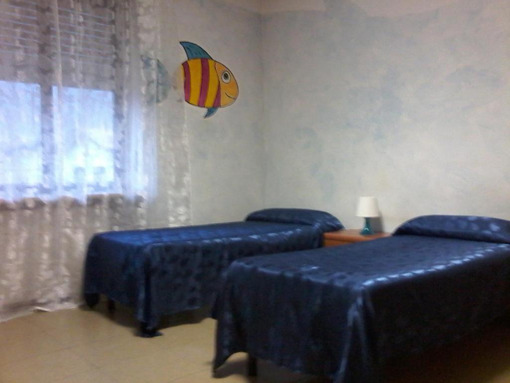 a room with two beds and a fish on the wall at Il Casello Verrès in Verrès