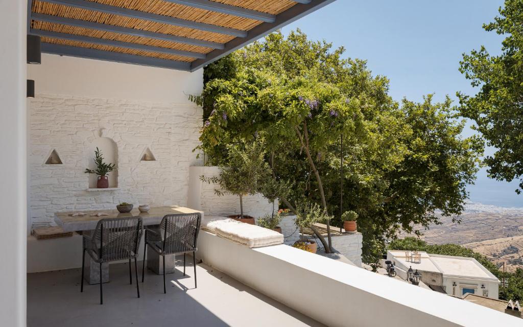a patio with a table and chairs on a balcony at Vivian Dio Choria Tinos in Dhió Kkhoriá