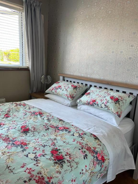 a bedroom with a bed with flowers on it at Private double room at Caroline's Guest House, River Street, Clara in Tara