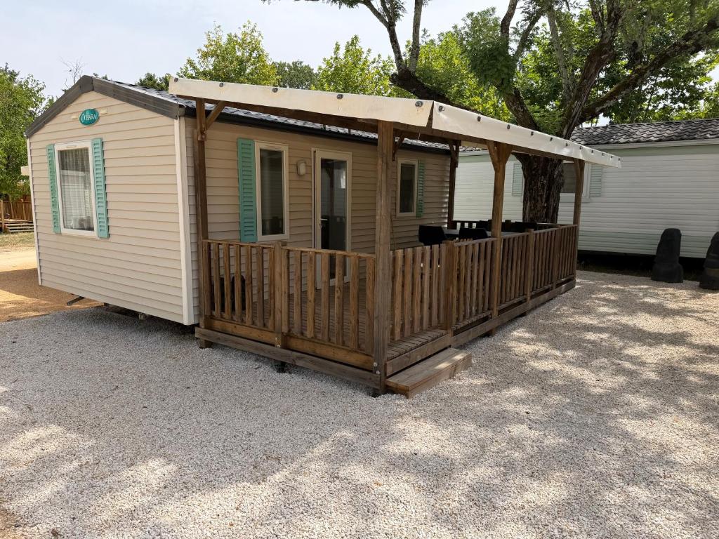 a mobile home with a porch and a deck at Chez Axel in Pradons