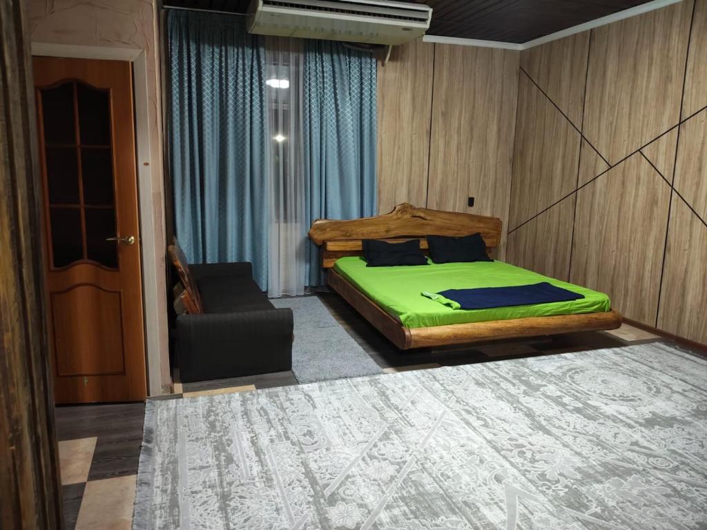 a bedroom with a green bed and a chair at SALEM hotel in Türkistan