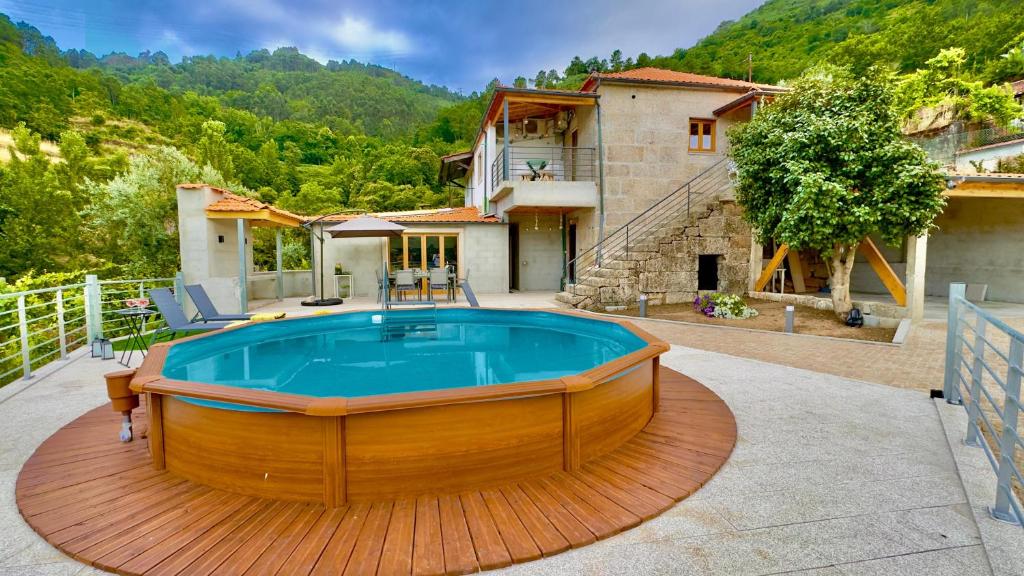 a house with a hot tub on a wooden deck at Refúgio do Espigueiro in Amarante