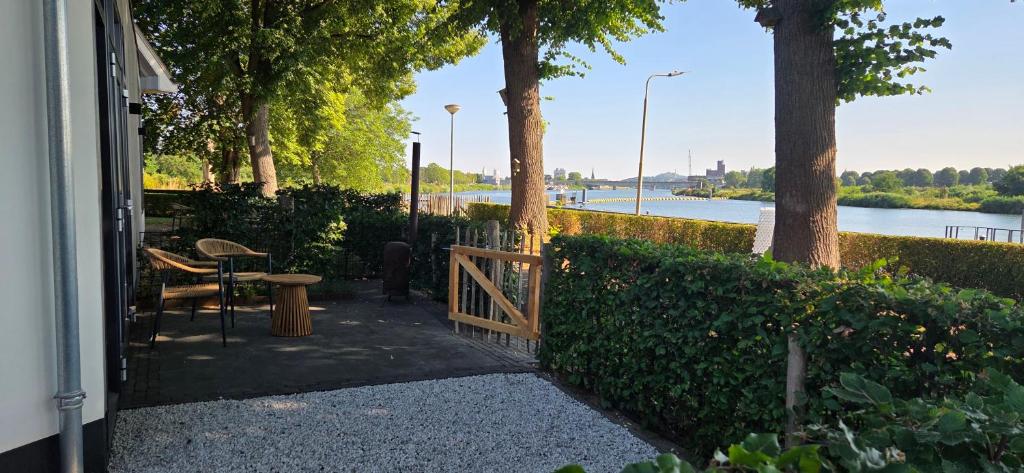 a porch with a fence and a table and trees at B&B La Rivé in Maastricht
