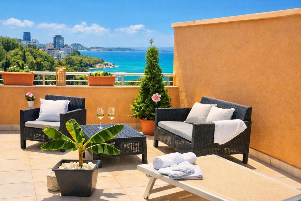 a balcony with chairs and a table with a view of the ocean at Durres Sun & Sea Luxury Apartment in Durrës