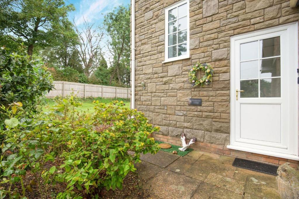 a cat sitting outside of a house with a door at 1 Bed in Raithby oc-h42745 in Raithby