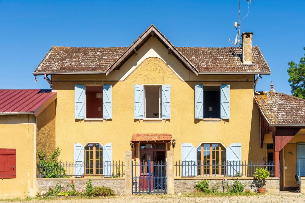 a yellow house with white windows and a fence at La Pausa Verda in Montréal