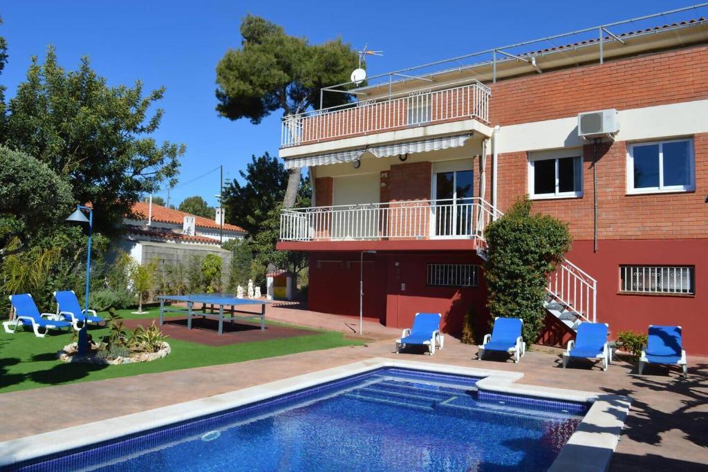 a house with a swimming pool next to a building at VILLA LAGEM, Casa con piscina, barbacoa, jardín in Cubelles