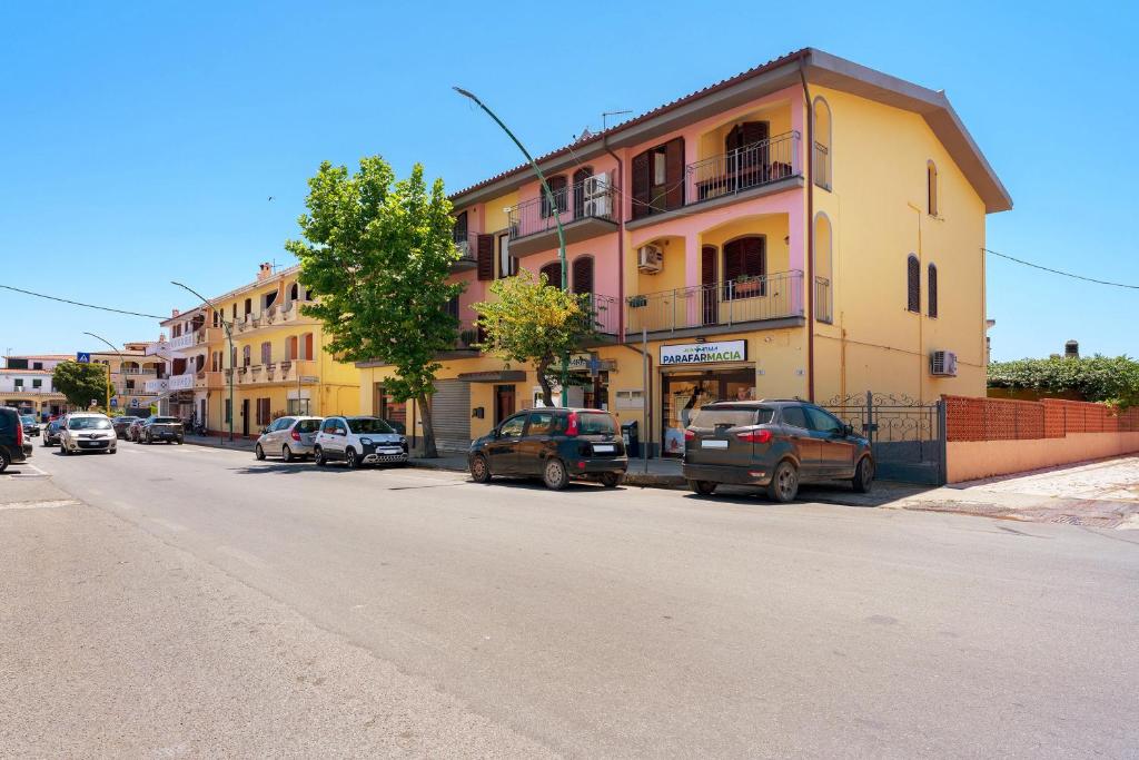 ein Gebäude mit am Straßenrand geparkten Autos in der Unterkunft Nurache in Orosei