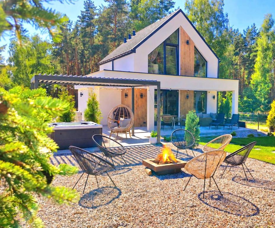 a backyard with chairs and a fire pit at Bosarosa Forest & Lake Villa z jacuzzi wanna SPA in Laski Małe