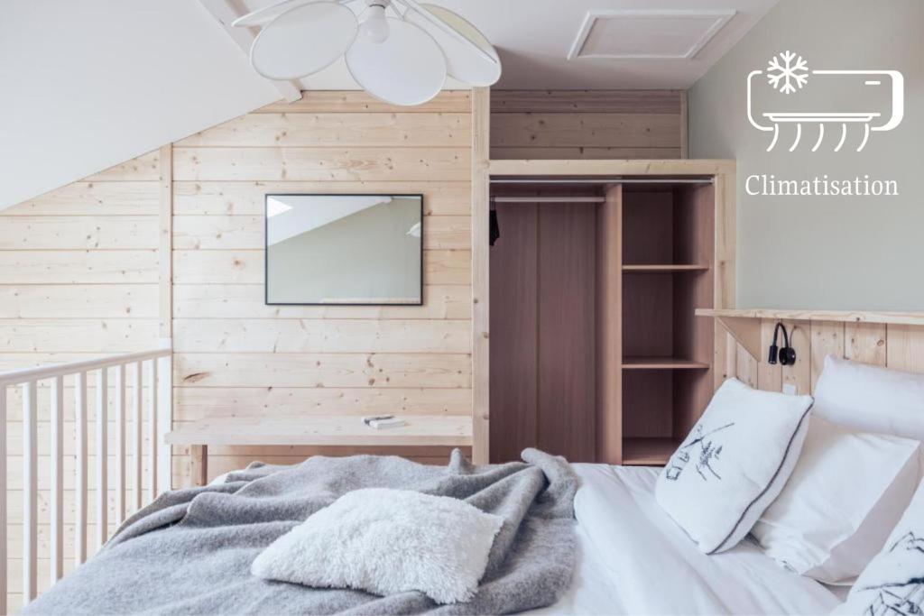 a bedroom with a bed and a tv on a wall at Le Clos du 5 - Appart Hotel Bagneres in Bagnères-de-Bigorre