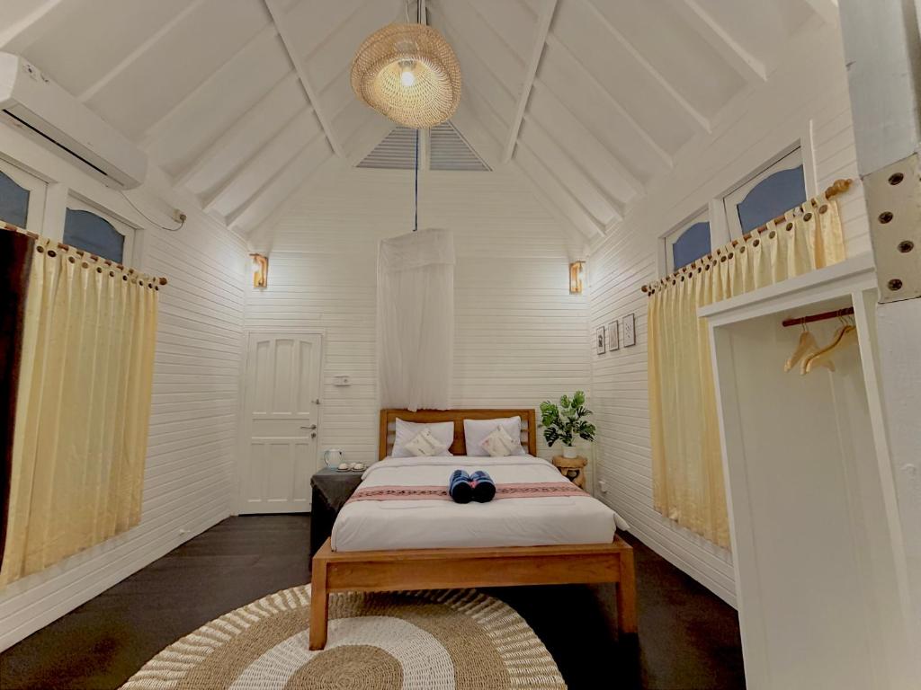 a bedroom with a bed with a table in it at Bronze Bungalows in Gili Meno