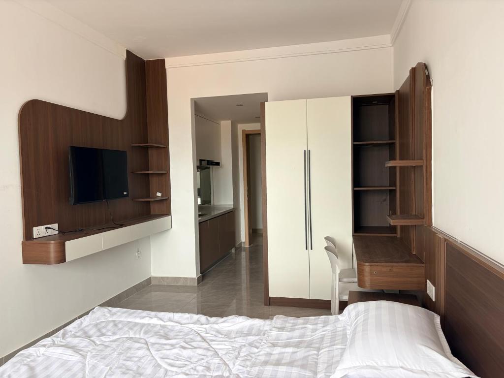 a bedroom with a bed and a desk and a tv at FryB in Phnom Penh