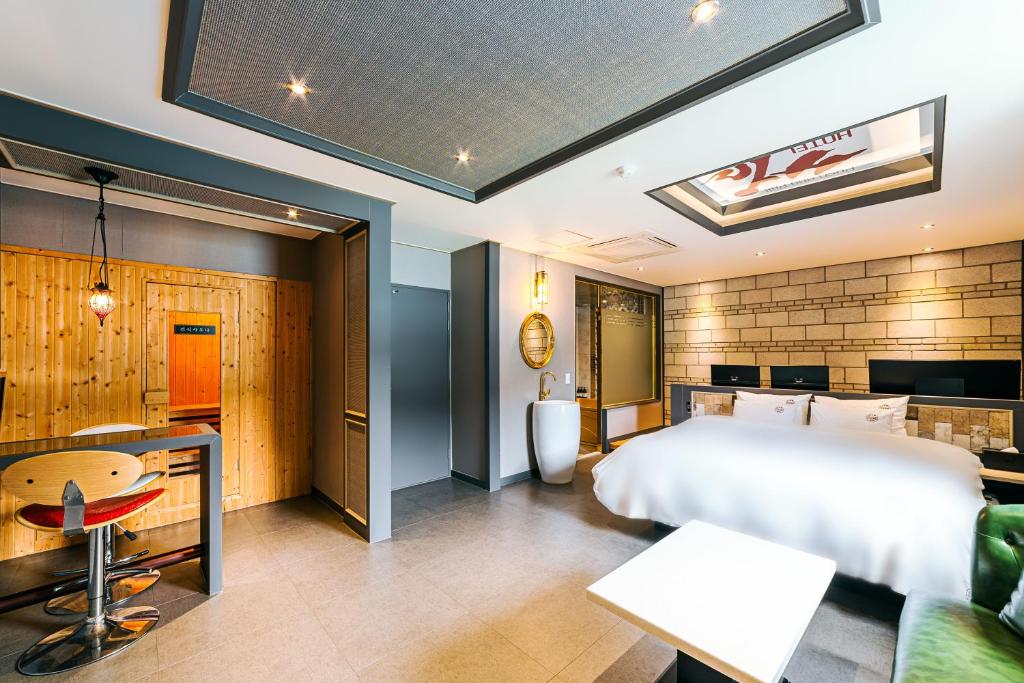 a bedroom with a large bed and a desk at Hotel Ssome Jeongkwan in Busan