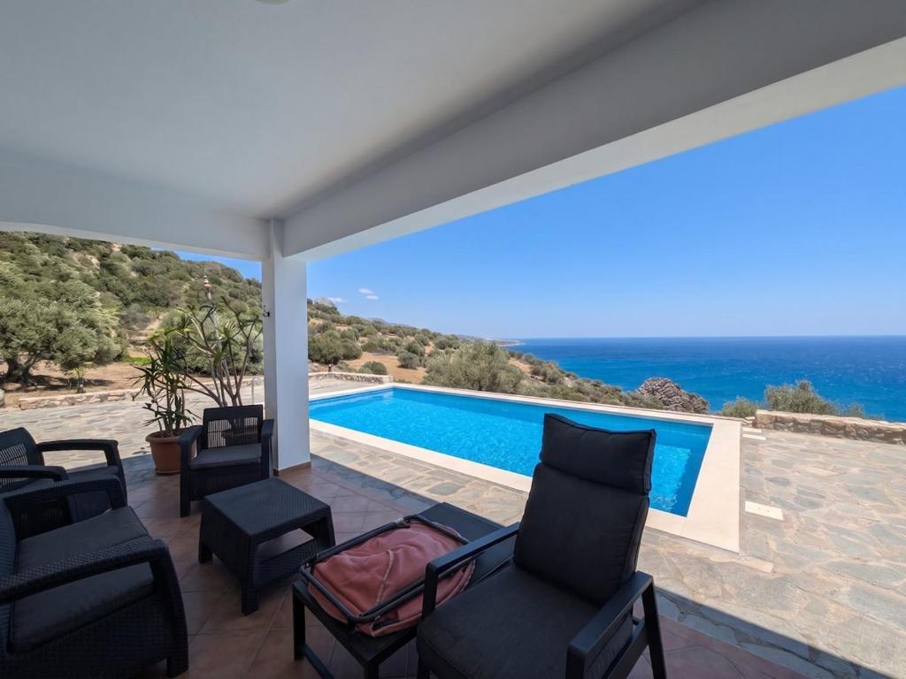 a patio with chairs and a swimming pool at Villa Belo in Kastrí