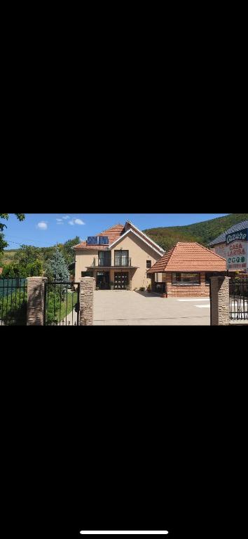 two pictures of a house with a fence at Casa Larisa in Chişcău