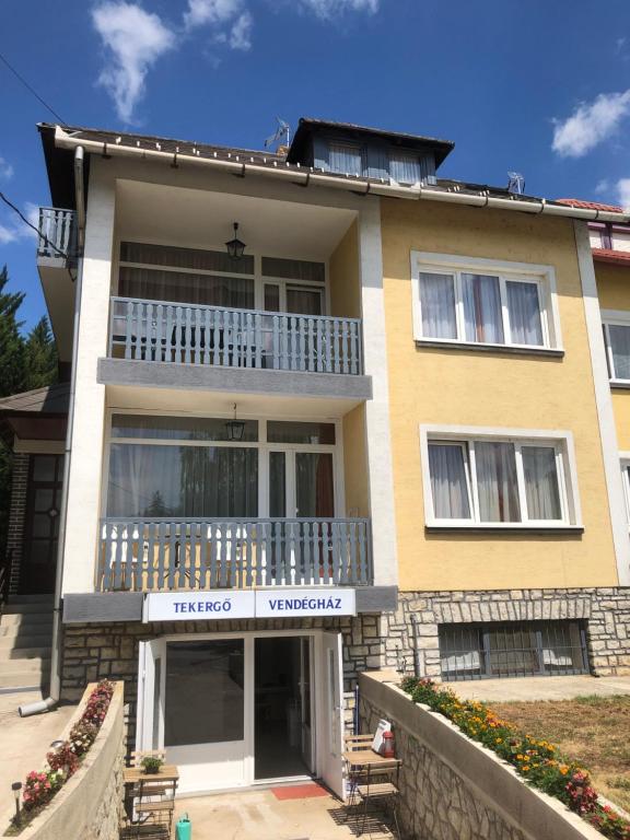 a large yellow house with a balcony at Tekergő Vendégház in Balatonfüred