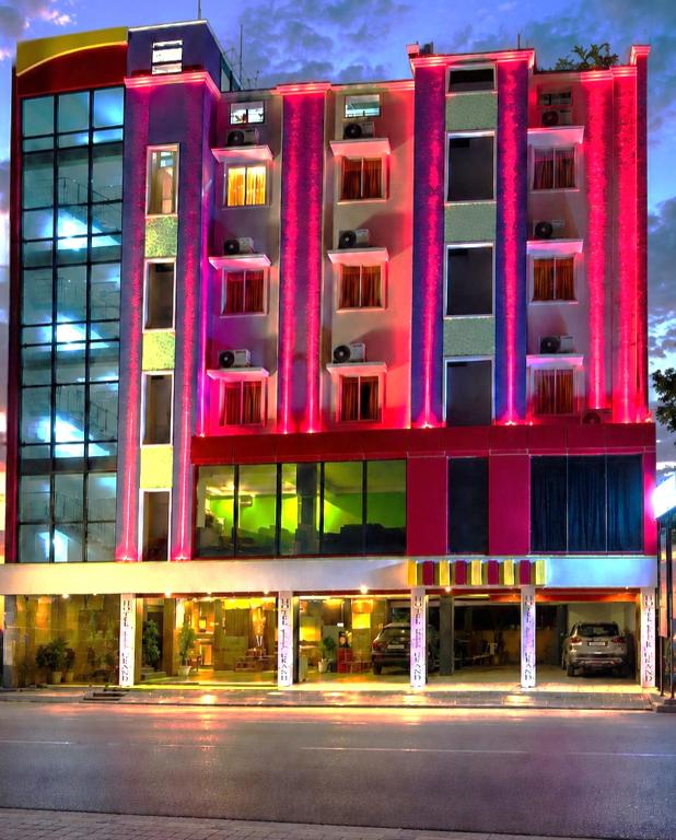 a large building with a pink facade on a street at Hotel KSR Grand in Srikalahasti