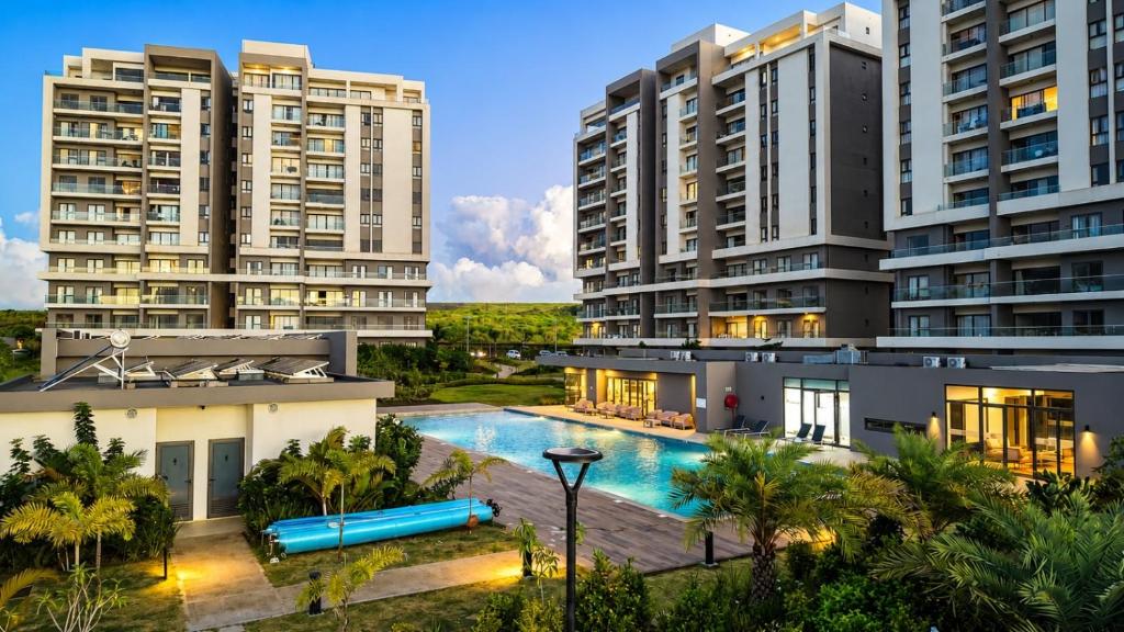 an image of two apartment buildings with a swimming pool at Minissy Suites in Moka