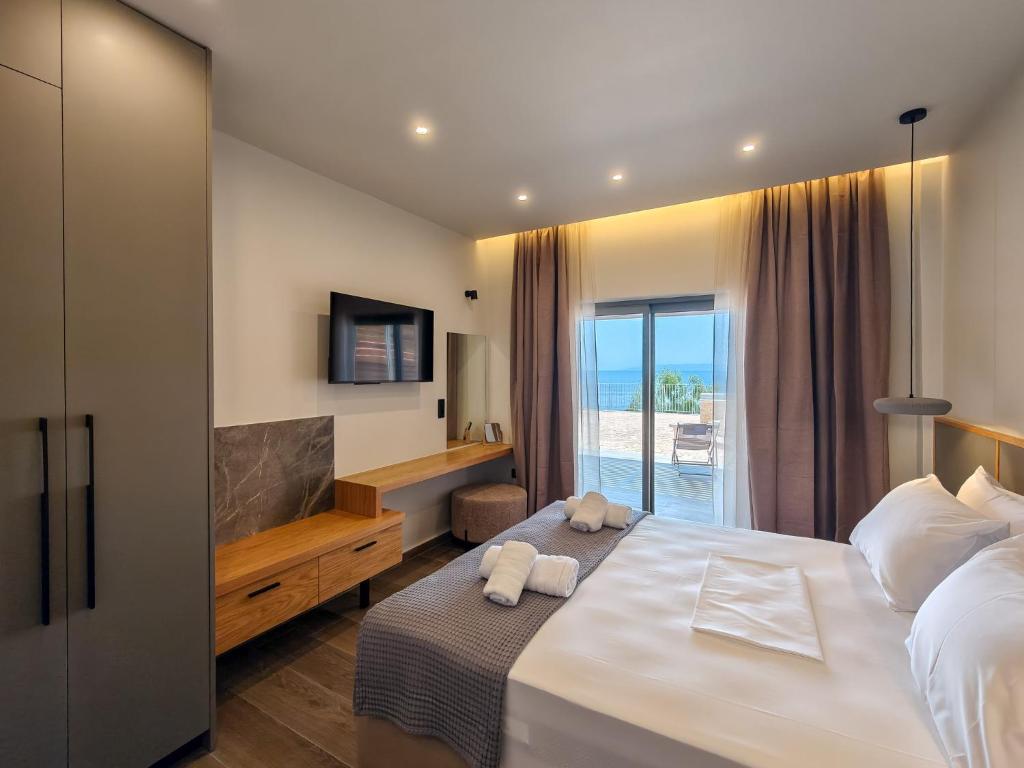 a bedroom with a bed and a tv and a window at Dimitra's Studios in Stoupa