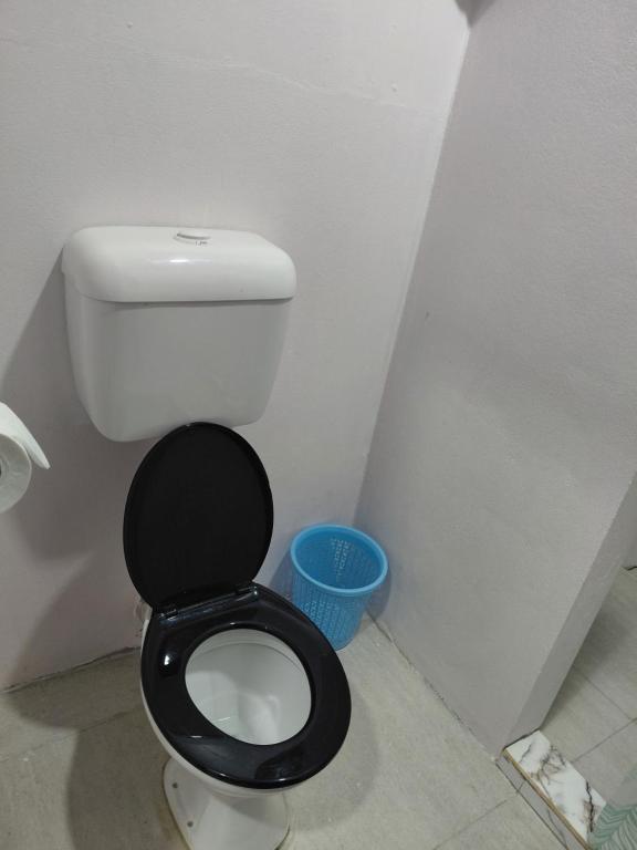 a bathroom with a toilet with a black seat at Standard - Bluelight Village Hotel in Nadi