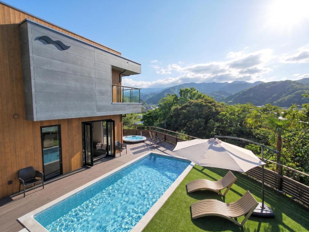 a villa with a swimming pool and a house at REQUIES first bloom in Kawazu