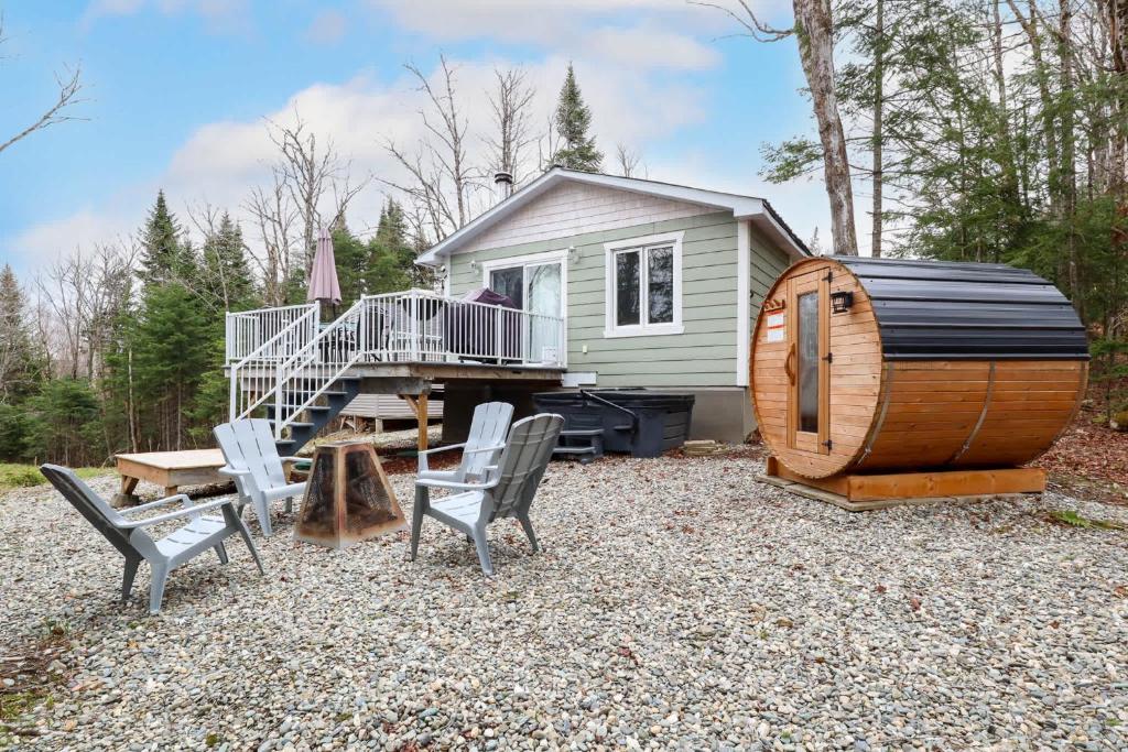 a tiny house with chairs and a wooden barrel at Spa & Sauna - Chalet de l'Ours noir in Notre-Dame-Des-Bois