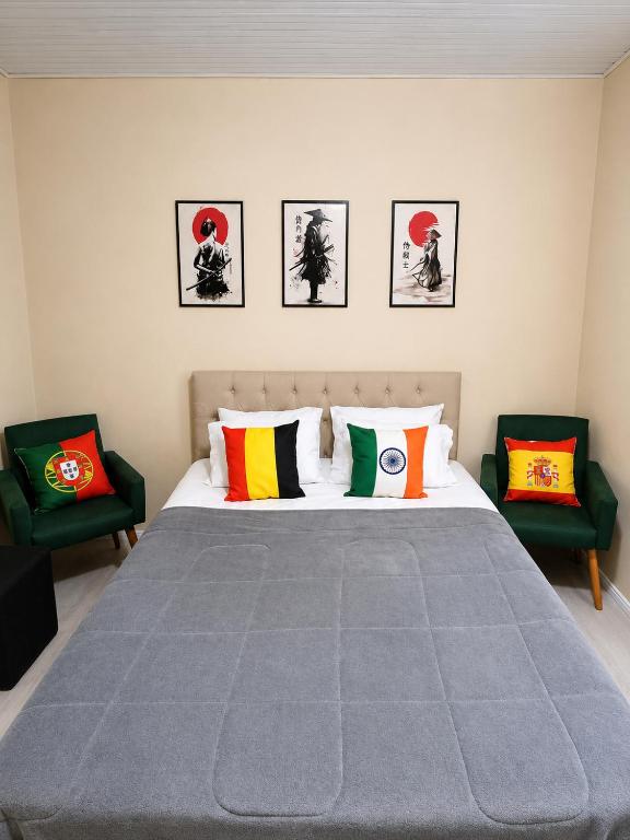 a bedroom with a large bed with two chairs at Mala & Café in Curitiba