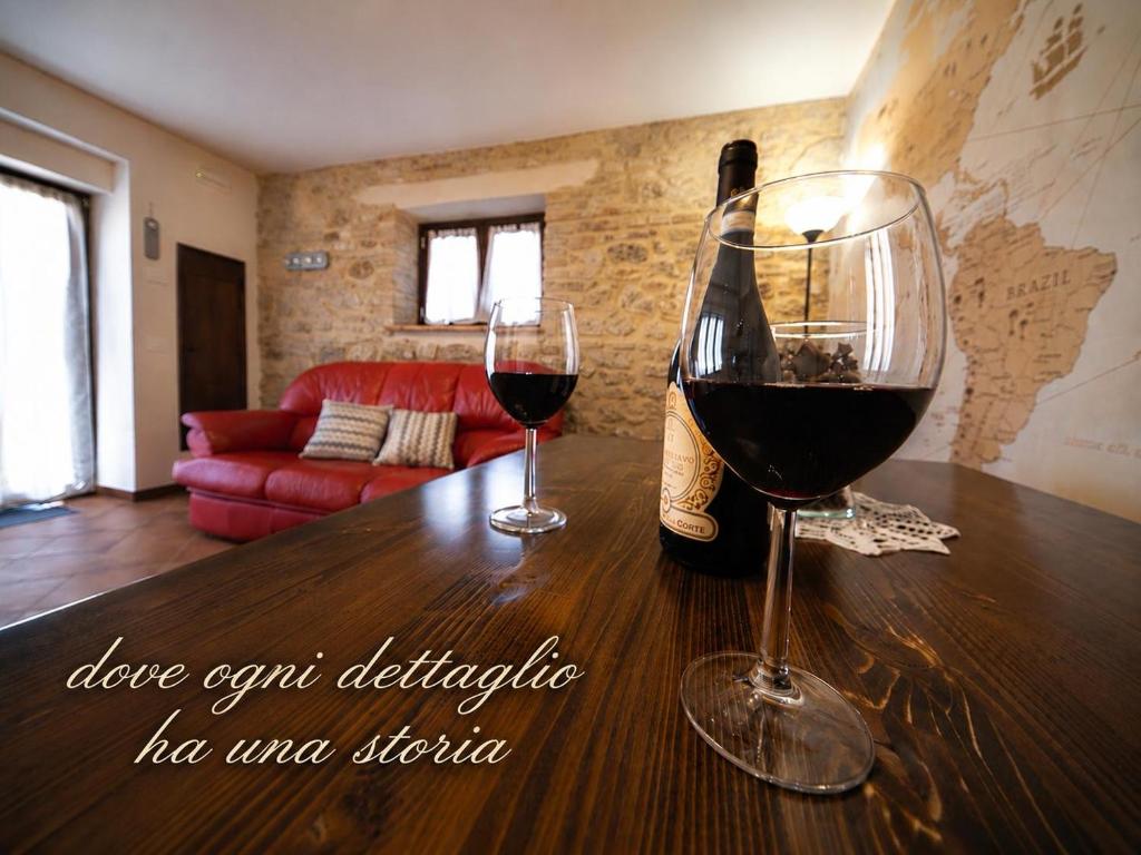 two glasses of wine sitting on a wooden table at L'Uggetto in Montecastrilli