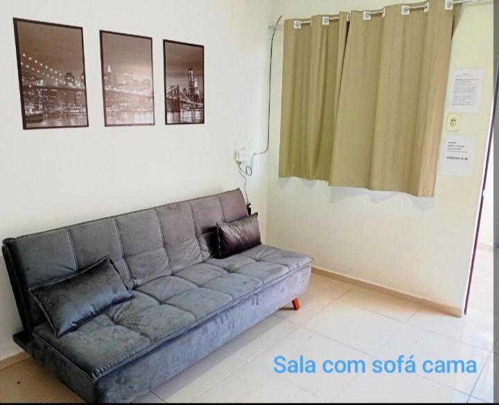 a living room with a couch and a curtain at Casa 2 quartos com garagem in Divinópolis