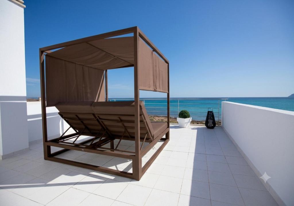 a chair on a balcony with a view of the ocean at Son Serra Sea Coast Villa in Son Serra de Marina
