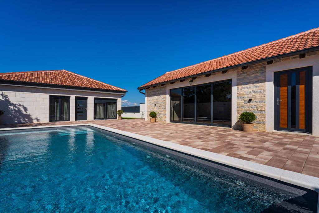 a swimming pool in front of a house at Kuća za odmor Leona in Dušić