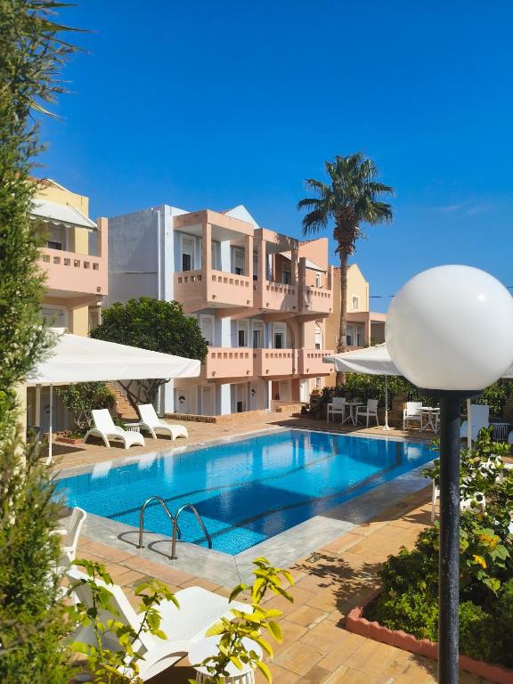 ein Schwimmbad vor einem Gebäude in der Unterkunft Toulipa Rooms in Agia Ermioni