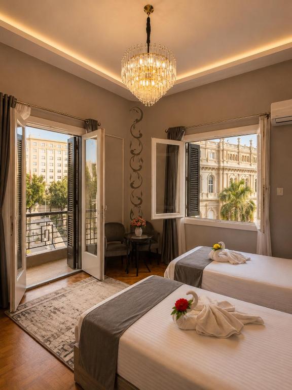 a hotel room with two beds and a chandelier at Grand City Hotel River View in Cairo