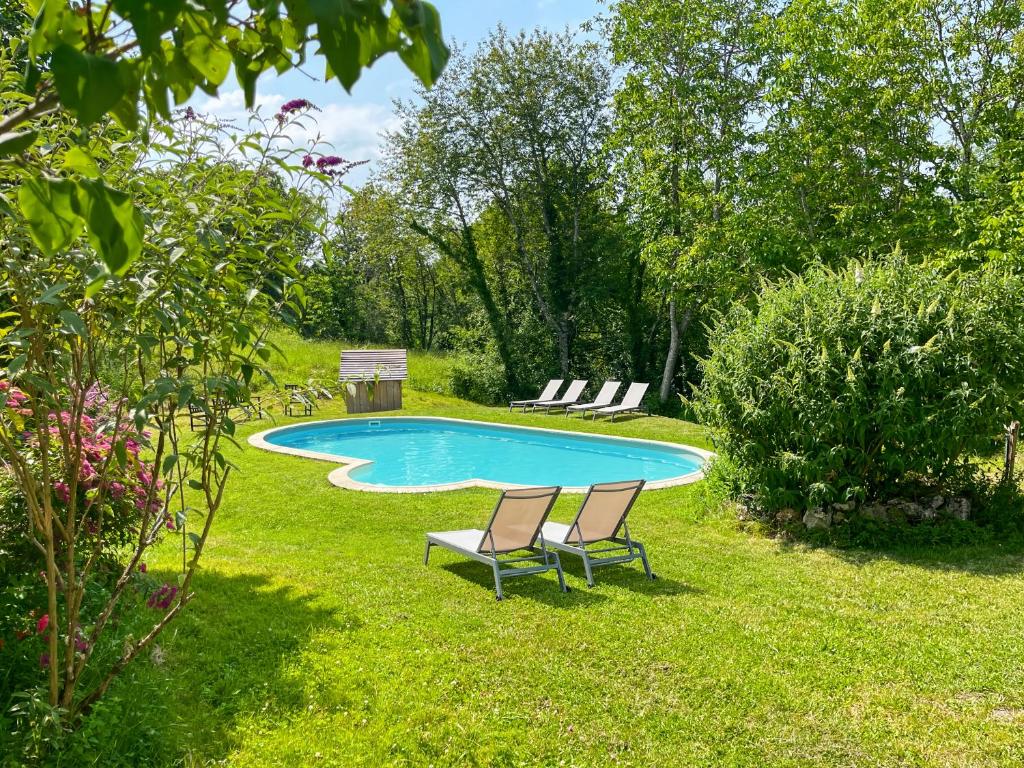 zwei Stühle und ein Swimmingpool in einem Garten in der Unterkunft Chambre d'Hotes Cugnac in Sainte-Sabine