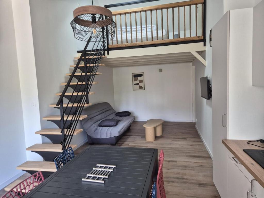 a living room with a spiral staircase and a couch at Maison bord de Loire Listing B in Saint-Rémy-la-Varenne