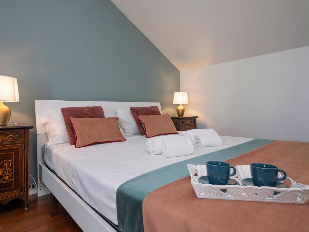 a bedroom with a bed with two mugs on it at NoLo Uptown Milano in Milan